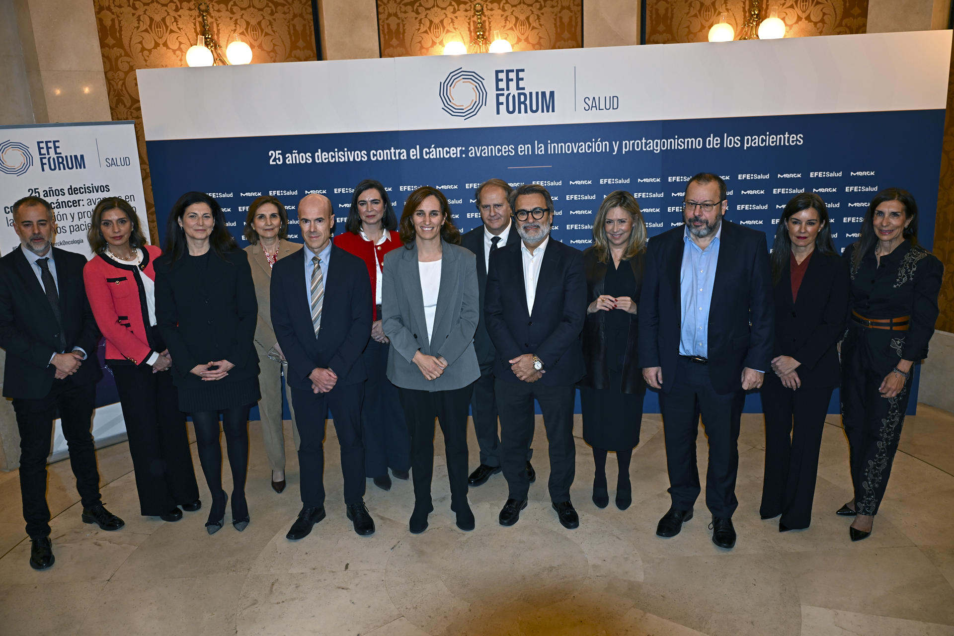 La ministra de Sanidad, Mónica García (c), el presidente de Merck en España Manuel Zafra (5d), el director de Información de la Agencia Efe, Leandro Lamor (5i), el director general de Cartera Común de Servicios del Sistema Nacional de Salud y Farmacia César Hernández (3d) y la comisionada del PERTE para la Salud de Vanguardia Raquel Yotti (3i), posan para fotografía de familia durante el Forum Efe Salud "25 años decisivos contra ele cáncer: Avances en innovación y protagonismo de los pacientes" organizado con Merck en el Teatro Real, en Madrid. EFE/ Fernando Villar